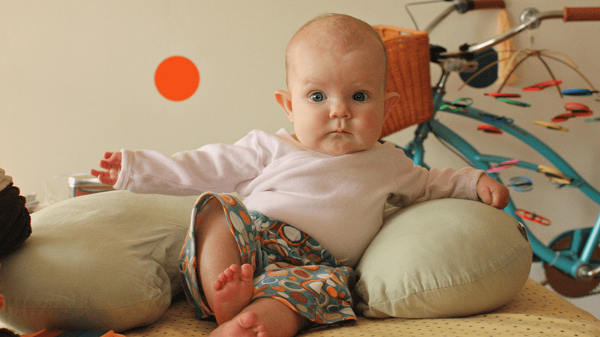 when the child begins to sit on his own