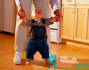 hold the baby by the hands and walk with him