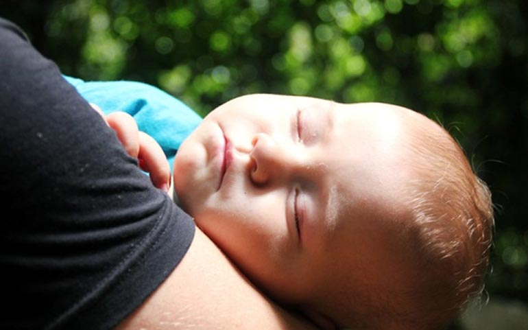 a baby’s sleep in mom’s arms