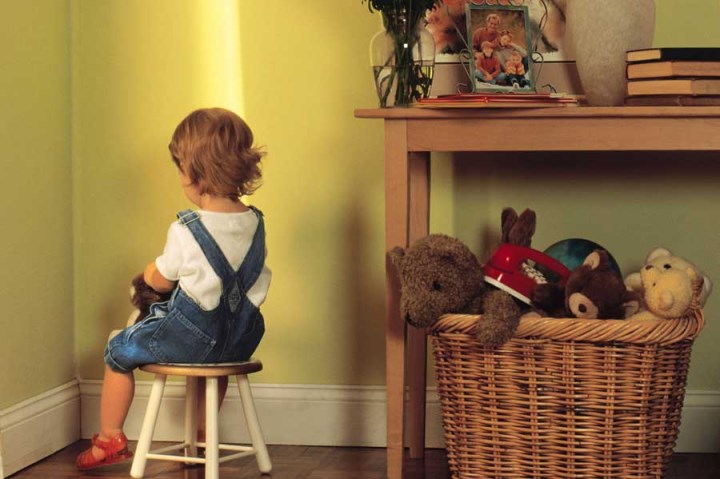 punishment of a child in a high chair in the corner